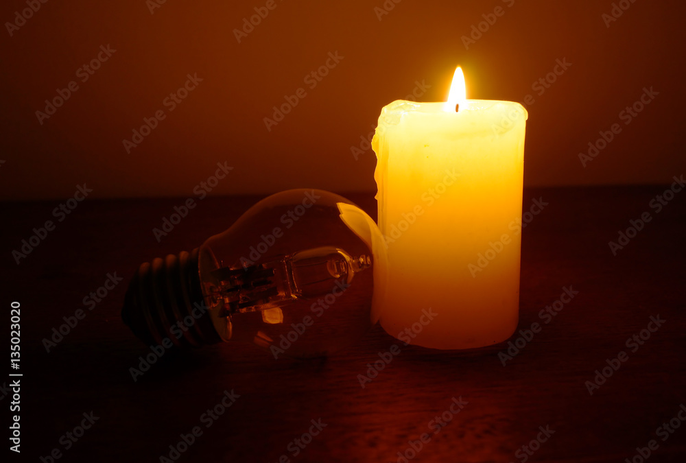 Burning candle and lamp on desktop. Power outage. Missing electricity - blackout begin.