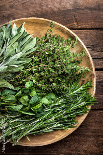 Photography various fresh herbs, rosemary, thyme, mint and sage on wooden background