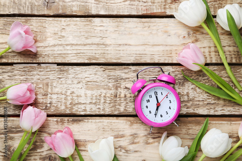 Fototapeta Naklejka Na Ścianę i Meble -  Bouquet of tulips with alarm clock on grey wooden table
