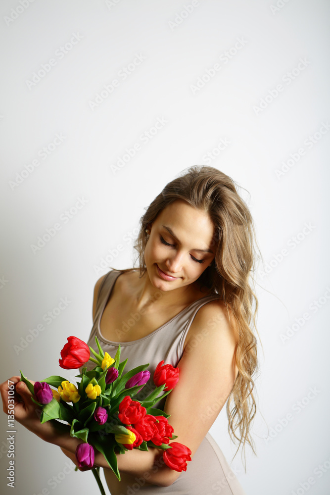 Cute girl holding a bouquet of colored tulips Cute girl holding a bouquet of colored tulips