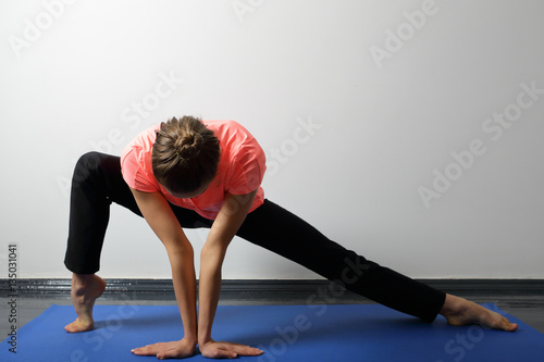 Woman trains stretching in a yoga studio