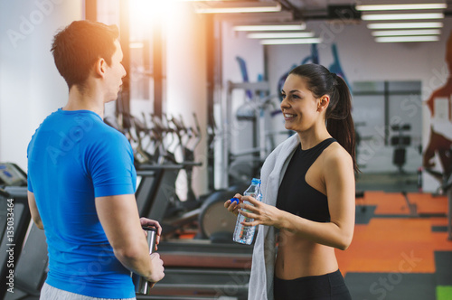 Fit woman discussing about gym with her personal trainer