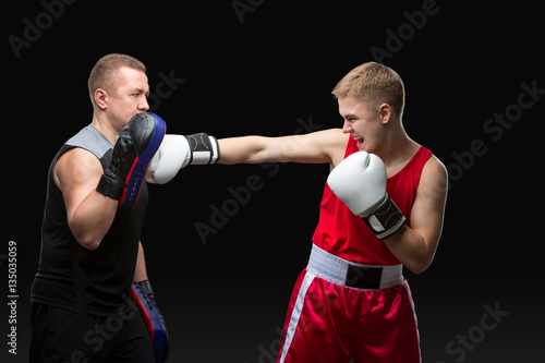 Young boxer working out with coach © svetography
