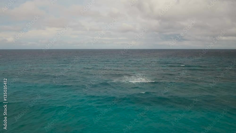 Flying over the blue sea in the azure lagoon in cloudy, stormy weather. Aerial view: water surface. Stormy sea against the backdrop of an overcast sky and clouds. Tropical sea. Boracay island Flying over the blue sea in the azure lagoon in cloudy, stormy weather. Aerial view: water surface. Stormy sea against the backdrop of an overcast sky and clouds. Tropical sea. Boracay island
