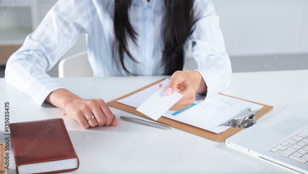 Businesswoman holding blank visit card ,sitting on the desk Businesswoman holding blank visit card ,sitting on the desk