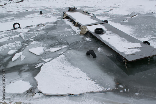 Frozen river with accumulated drift ice putting preasure on dock photo