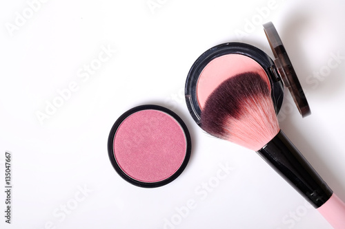 Cosmetic pink blush on and makeup brush.