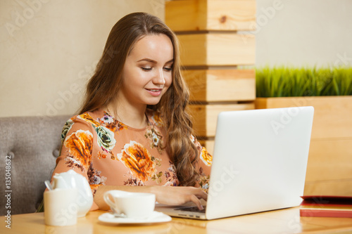 girl smiling printing at the laptop