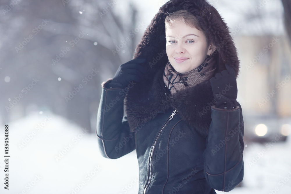 Winter woman in a fur coat on the snow outside