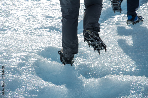 caminando con crampones sobre el hielo photo