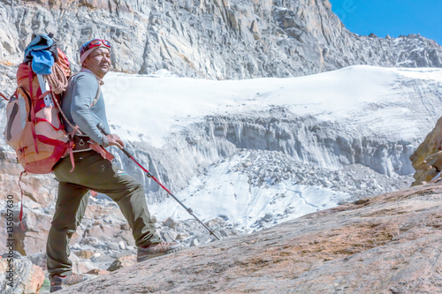 Obraz na plátne Nepalese Mountain Guide staying on top of high Rock