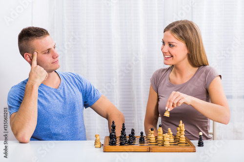Happy couple enjoys playing chess. 