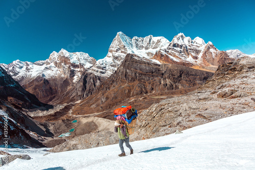 Fotografija Nepalese Porter carrying Basket with luggage of mountain expedition