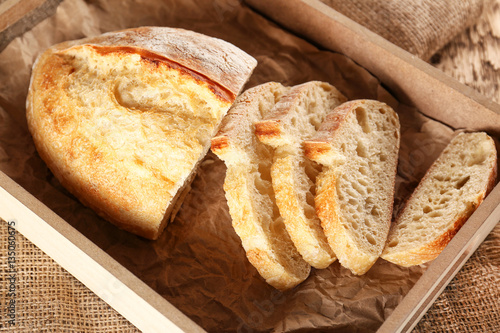 Sliced fresh bread in wooden box closeup