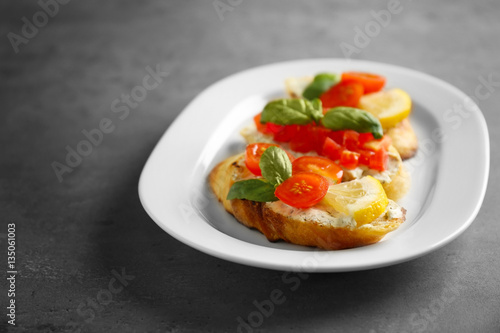 Delicious toast with tomatoes on plate
