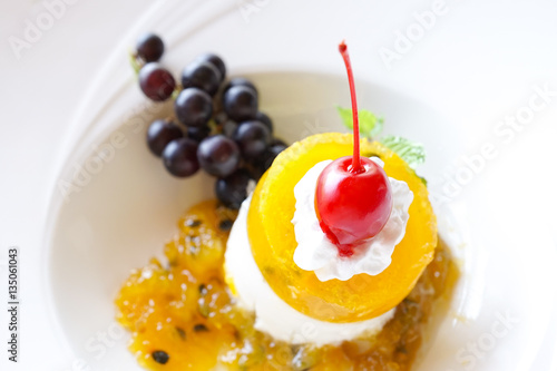 Panna cotta decorated with berries closeup, passion fruit panna cotta, or mango panna cotta