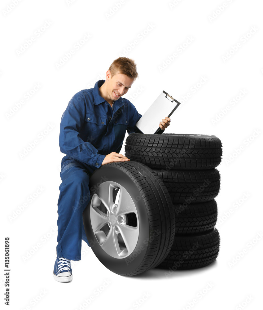 Young mechanic in uniform with a clipboard on white background