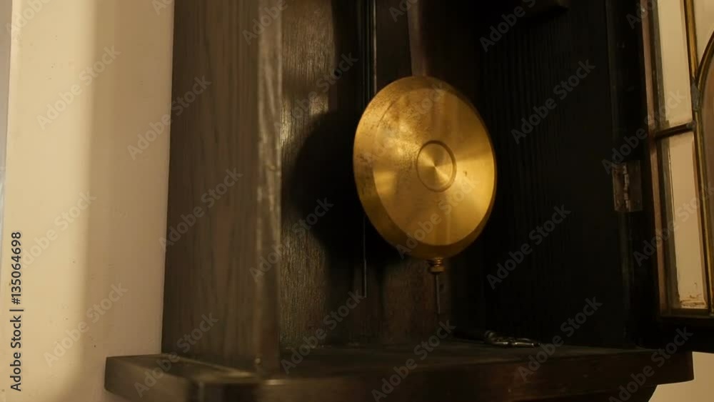 Antique wall clock with a pendulum. Man's hand starts pendulum, closeup. Antique wall clock with a pendulum. Man's hand starts pendulum, closeup.