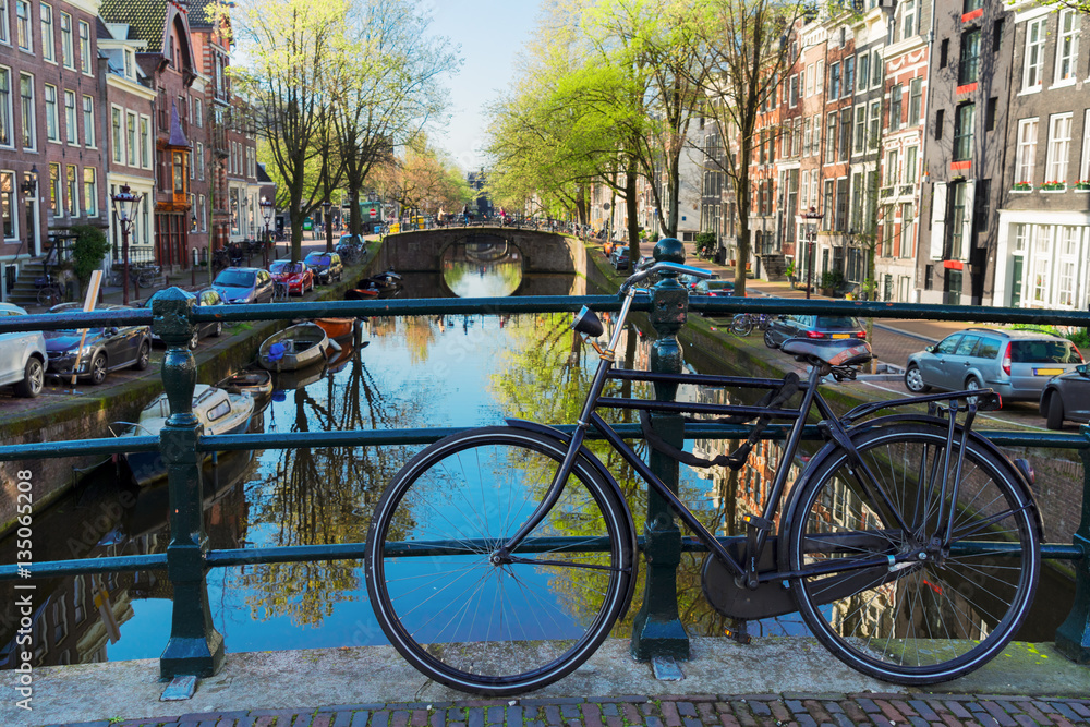bicycle standing on the bridge next to canal in Amsterdam, Netherlands