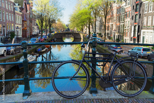 bicycle standing on the bridge next to canal in Amsterdam, Netherlands