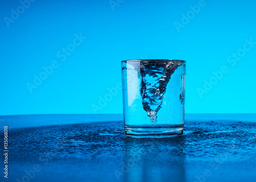 fresh clear blue water splash in glass