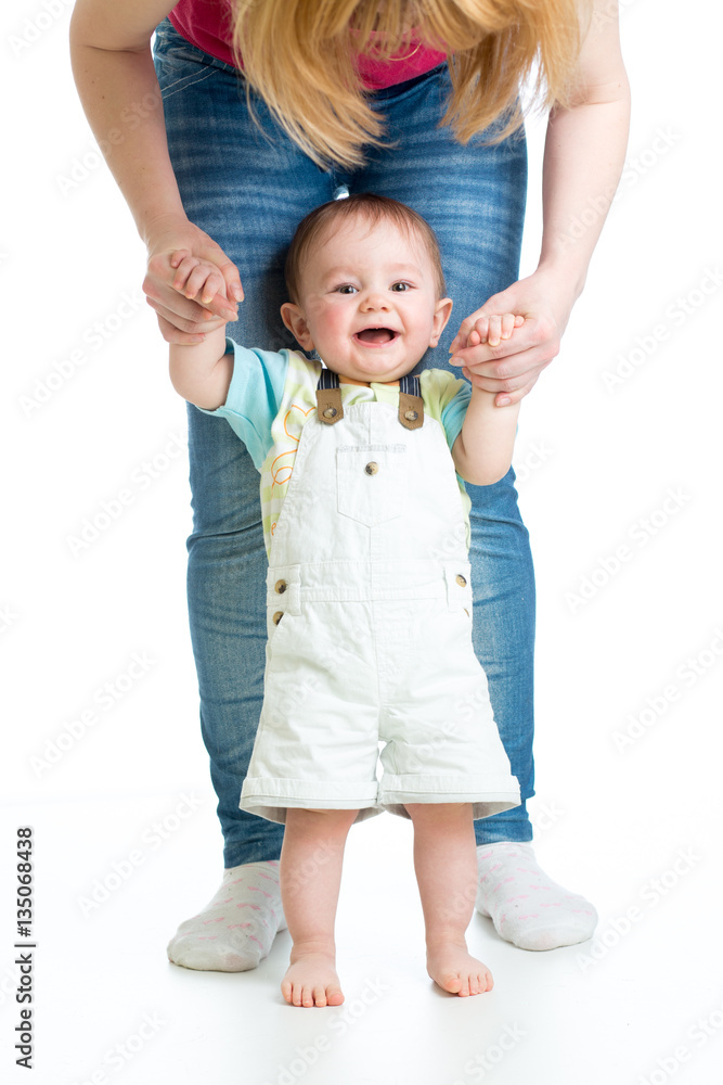 little baby boy doing first steps with mother support little baby boy doing first steps with mother support