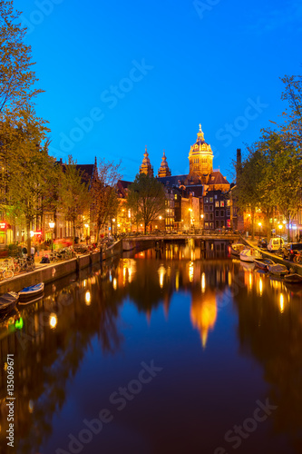 Church of St Nicholas over old town canal at night, Amsterdam, Holland Netherlands