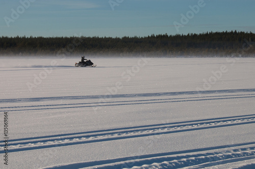 One person riding a snowmobile on a frozen lake in Sweden 