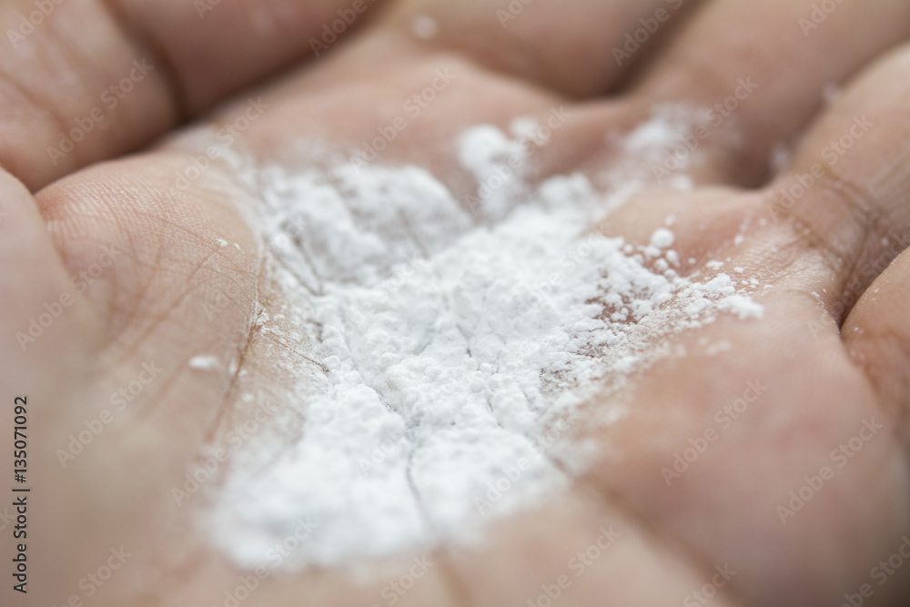 Closeup of white powder on hand