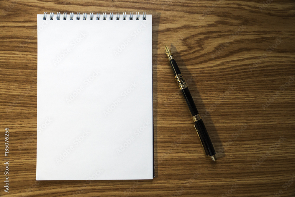 Notebook and fountain pen on wooden background Notebook and fountain pen on wooden background