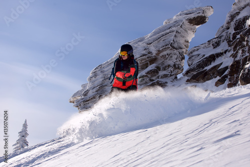 Fast snowboarder downhill in powder.