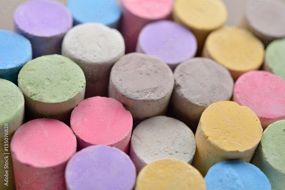 Macro picture of chalks in a variety of colors on a white backgr Macro picture of chalks in a variety of colors on a white backgr