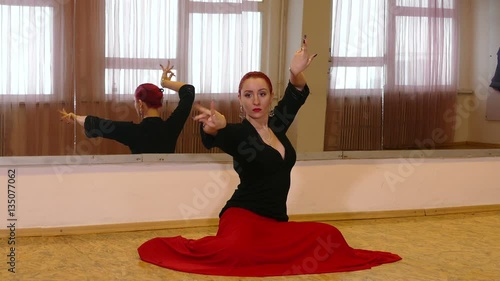 young woman sitting on the floor and dancing flamenco