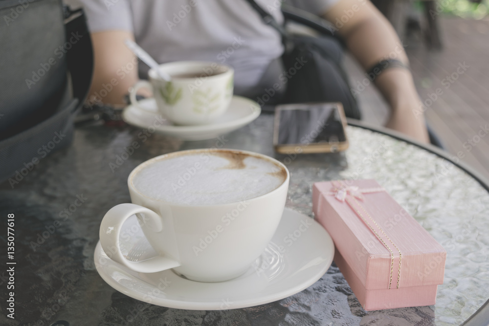 Selective focus white cup of Coffee, latte on the wooden table with pink gift. Selective focus white cup of Coffee, latte on the wooden table with pink gift.