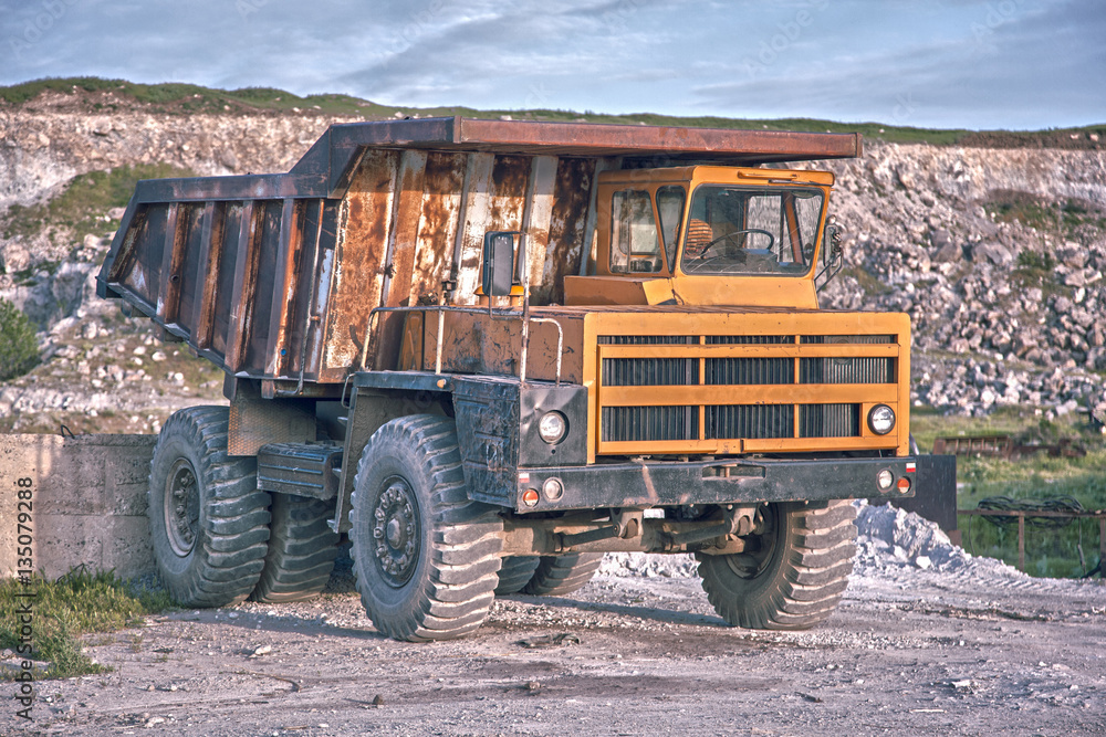Heavy mining truck driving through the iron ore opencast