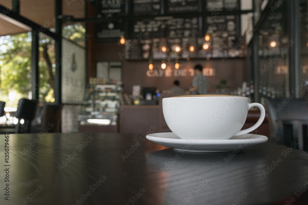Fototapeta Filiżanka kawy na drewnianym stole w kawiarni.
