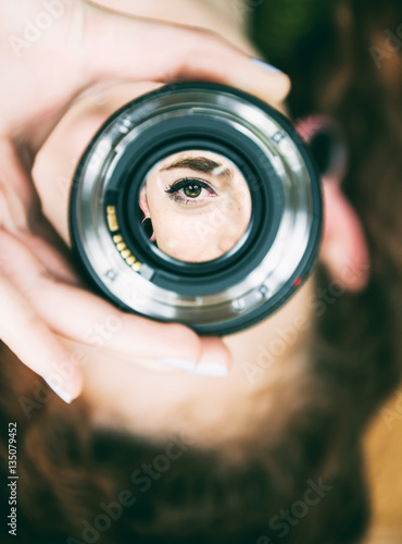 Ojo de una mujer enfocado desde un objetivo de fotografía  photo
