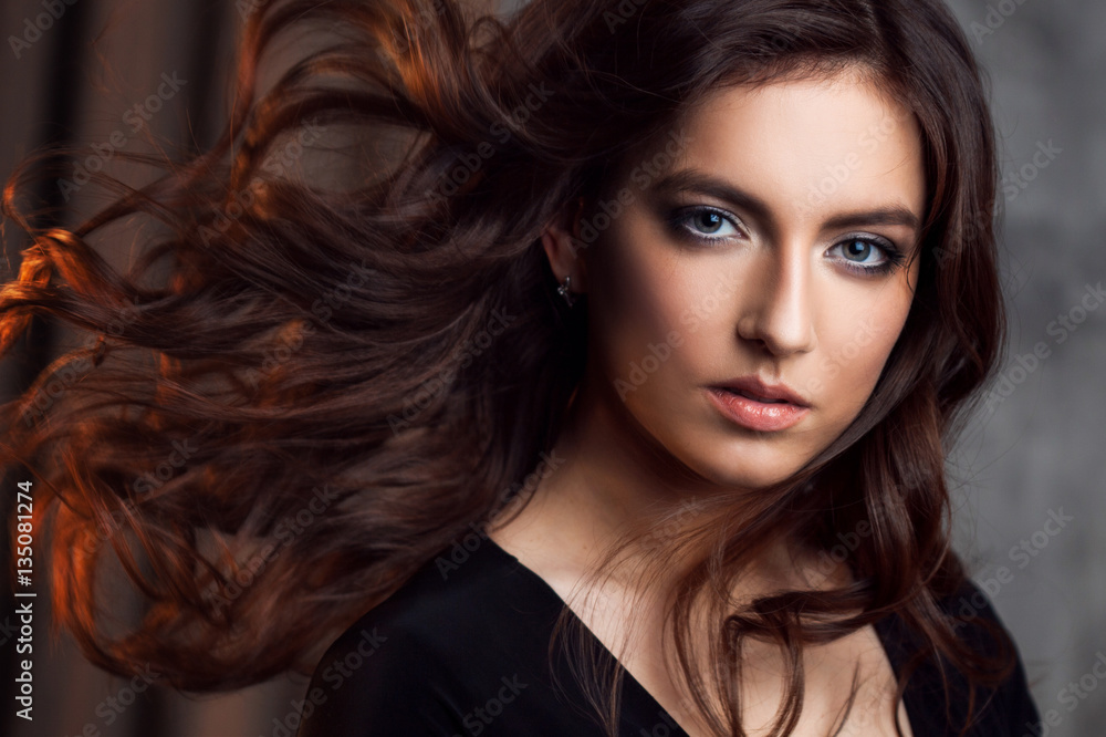 Fototapeta premium Delightful portrait of a woman brunettes, hair flying on the wind, sloppy styling