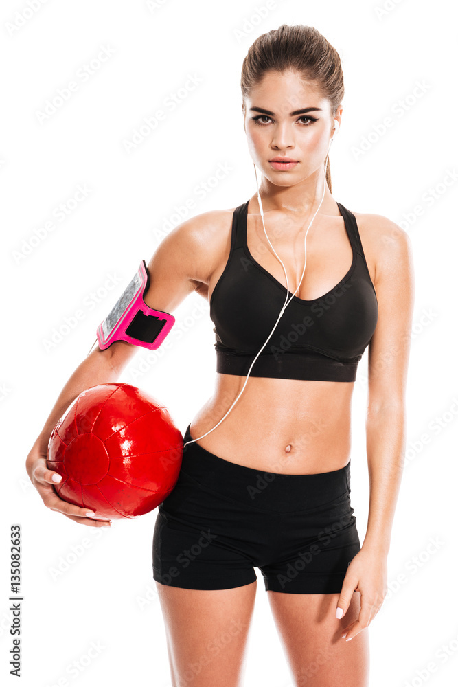Fitness sexy woman standing and holding pilates ball Fitness sexy woman standing and holding pilates ball