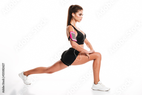 Side view portrait of a young pretty sportswoman doing squats © Drobot Dean