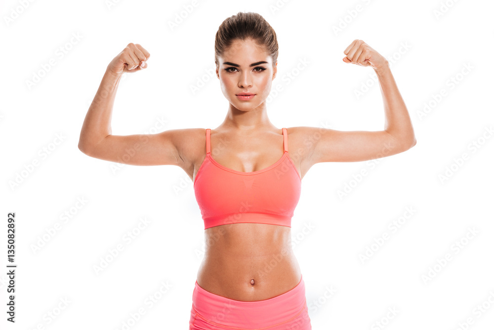 Young smiling woman in sports wear showing her biceps Young smiling woman in sports wear showing her biceps