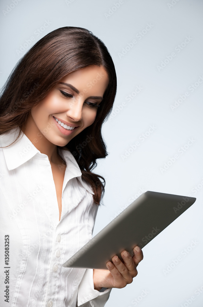 businesswoman using no-name tablet pc, over grey businesswoman using no-name tablet pc, over grey