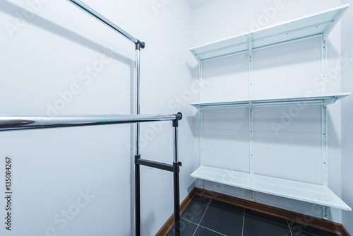 The interior of the new dressing room with hangers and shelves for clothes in white