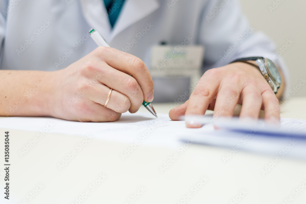 male doctor sitting table writing. hands male doctor sitting table writing. hands