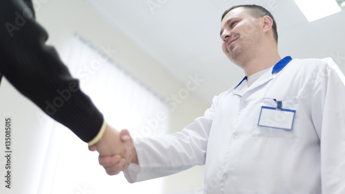 Doctor hand shaking with man in hospital