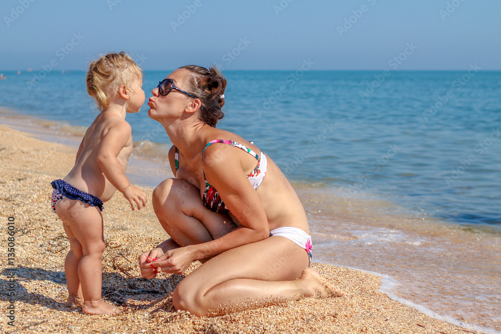 Little baby girl with mother on beach Little baby girl with mother on beach
