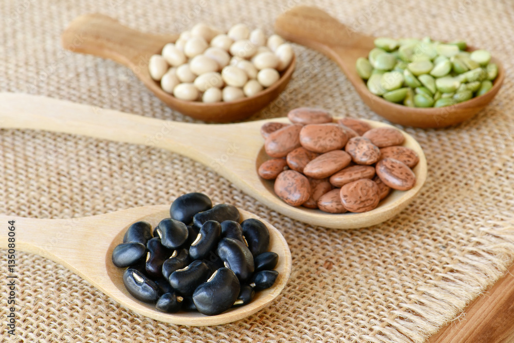 Prepared black bean on wooden spoon with many dried legumes Prepared black bean on wooden spoon with many dried legumes