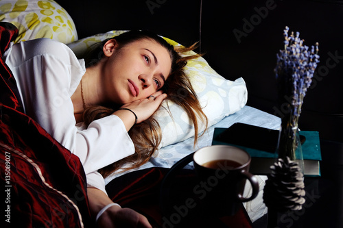 young girl in bed in the morning with a Cup of coffee