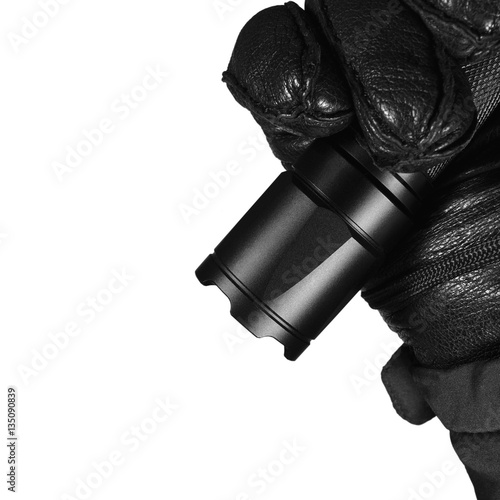 Gloved Hand Holding Tactical Flashlight Bright Light Brightly Lit Strike Bezel Black Grain Leather Glove Cop Jacket, Isolated Vertical Closeup, Police Security Guard Policeman Patrol, Forensic Officer photo