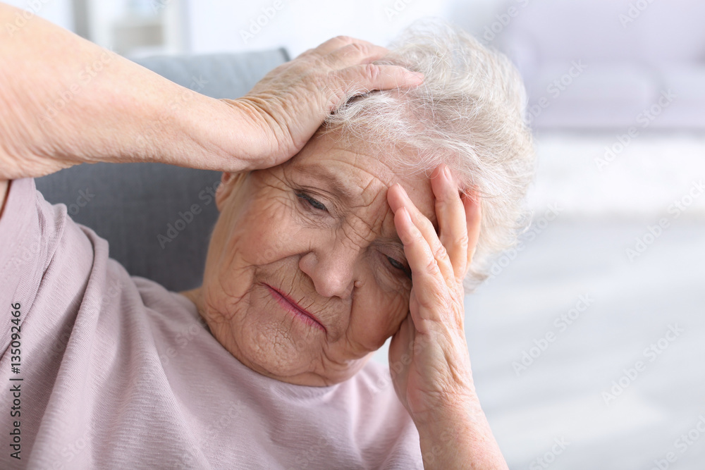 Elderly woman suffering from headache at home Elderly woman suffering from headache at home
